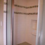 After photo - Bath remodel showing shower surround of subway tile with mosaic trim and Corian bench, Bellingham