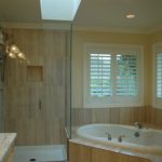 After - Master bath showing tiled shower walls with the same tile flowing around soaking tub. Glass walls on 2 sides of shower open up the room, Bellingham